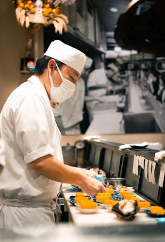 Chef plating dishes at a restaurant counter