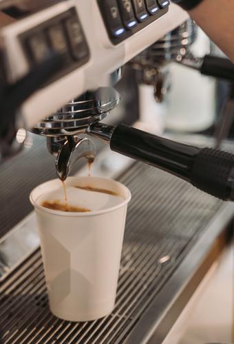 Espresso pouring into a takeaway cup